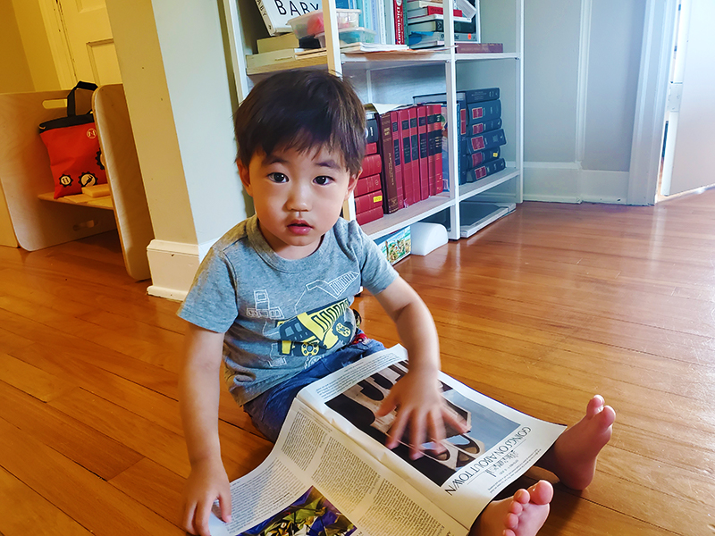 Ray reads a magazine on the floor.