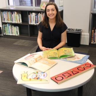 woman sitting at a table with literacy materials